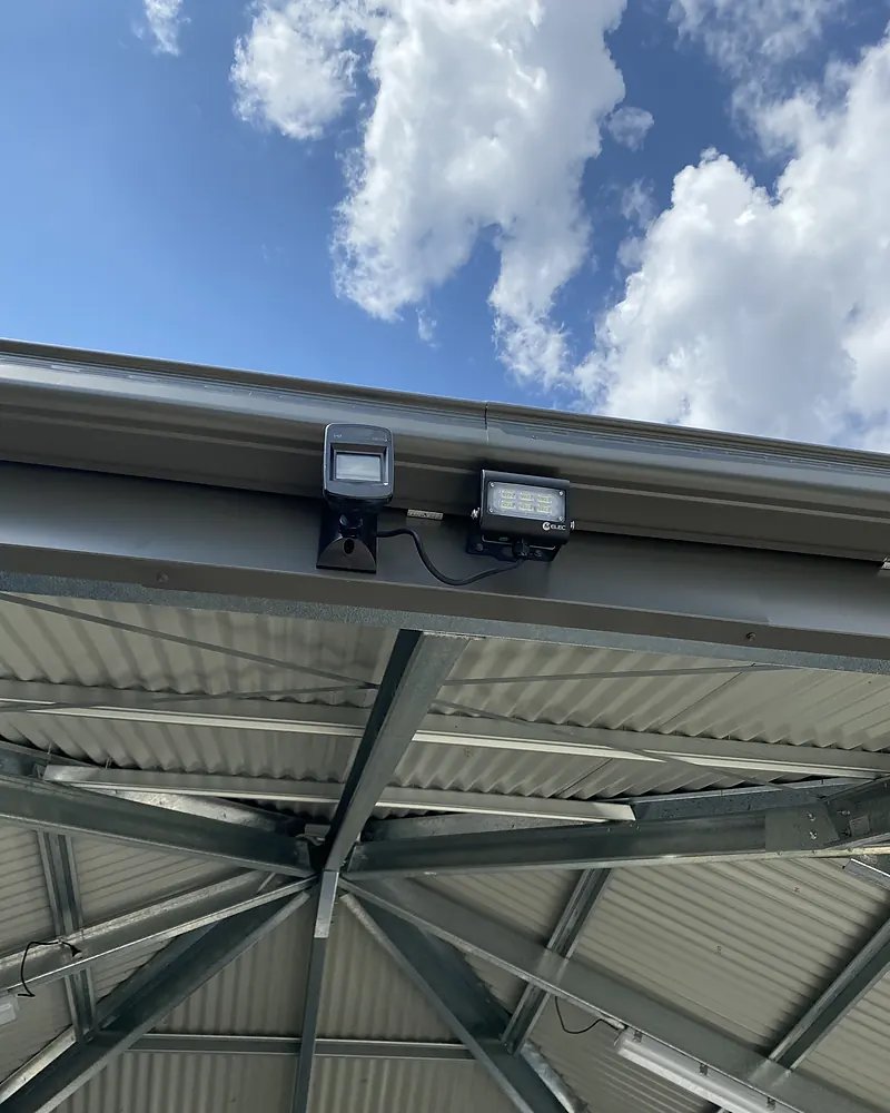 Two LED sensor flood lights fitted under a patio roof